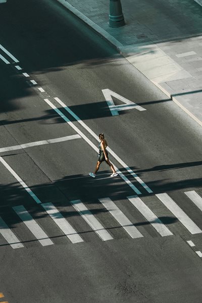 Kvinde passerer vej ved fodgængerovergang