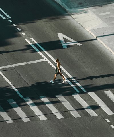 Kvinde passerer vej ved fodgængerovergang
