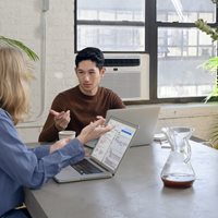To personer drøfter digitalisering ved deres computere